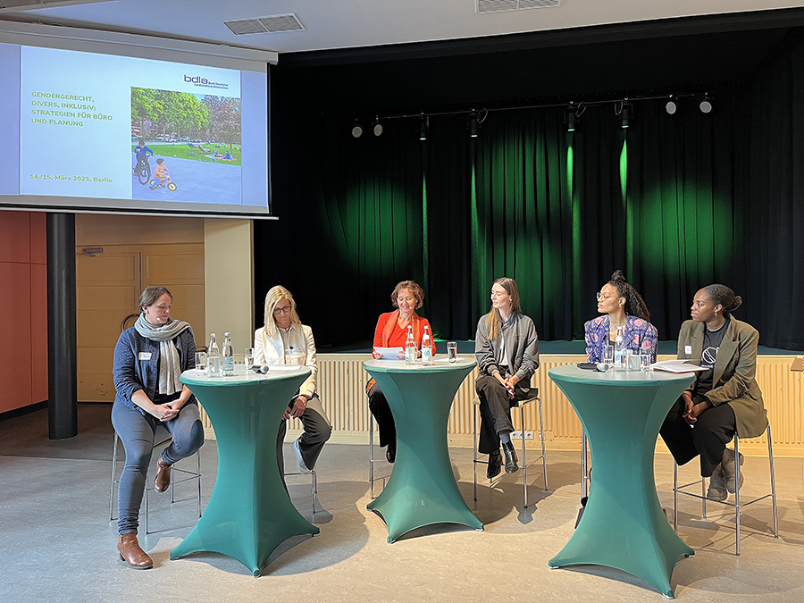 Die Teilnehmerinnen sitzen auf Hockern an drei Stehtischen