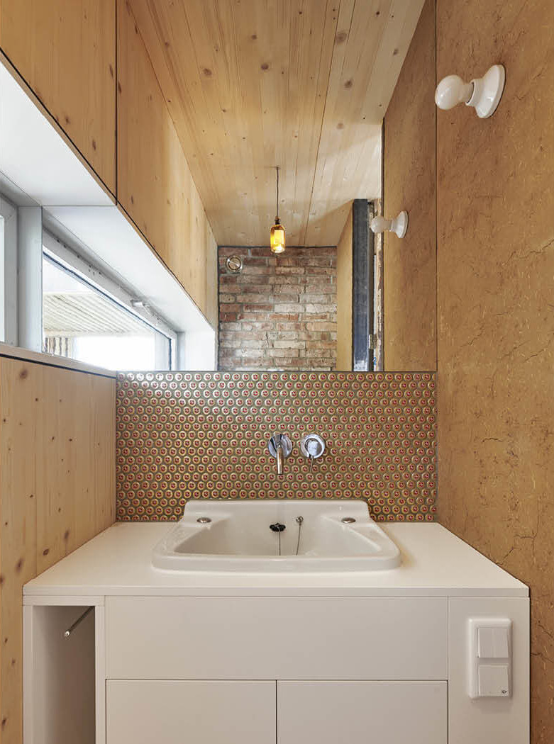 Zirkuläres Bauen im Recyclinghaus Hannover mit altem Waschbecken und Fliesen aus Kronkorken