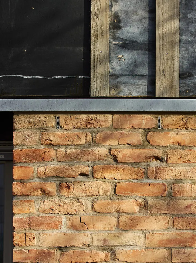 Wand aus weiderverwendeten Ziegelsteinen im Haus Klinge10