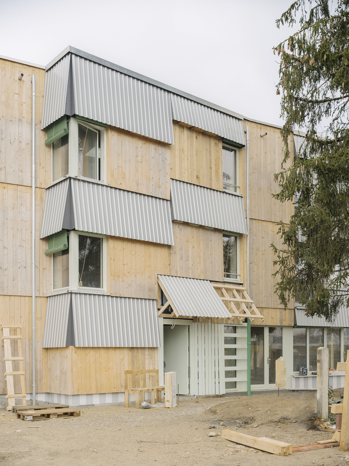 Baustelle eines Wohnhauses mit Holzfassade und Wellblech