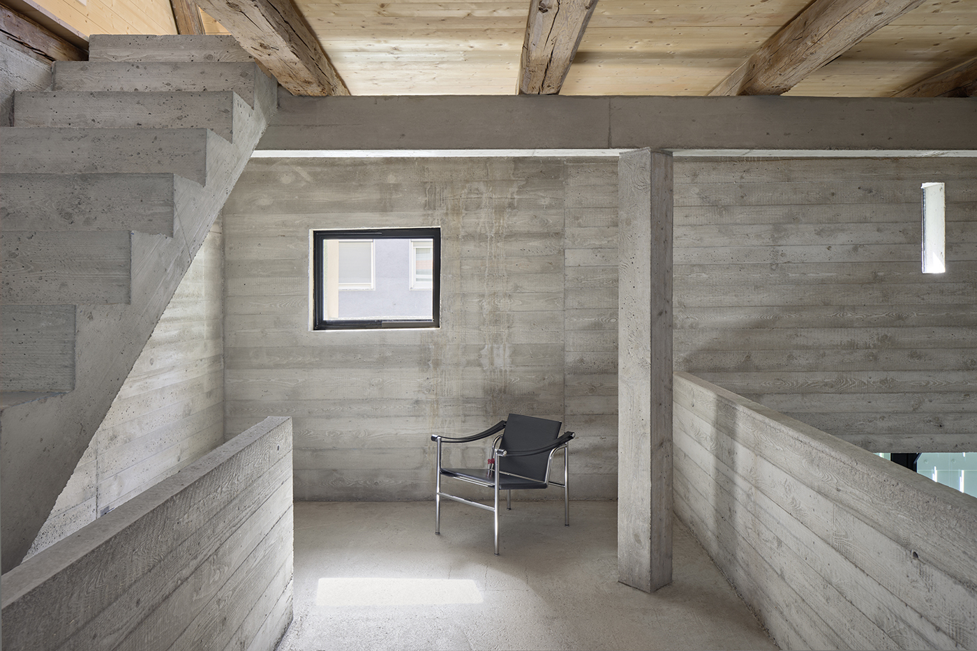 Raum mit Betonwänden, Treppe und Holzdecke