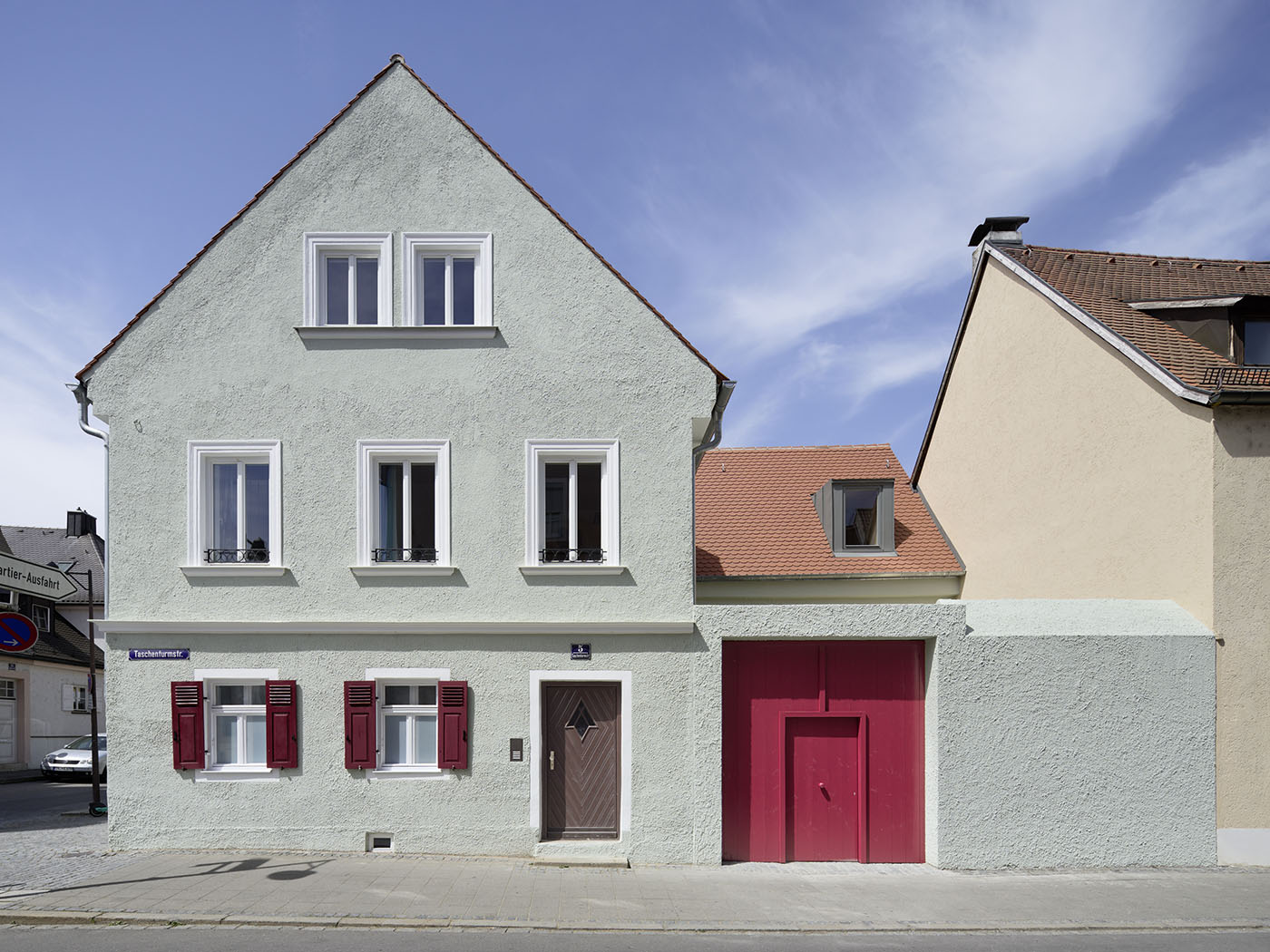 Stadtbauernhaus in Ingolstadt mit mintgrüner Fassade und roter Tür