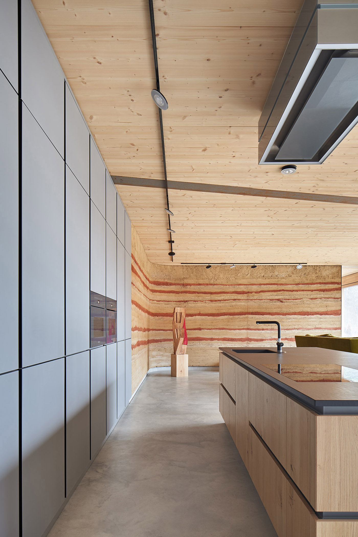 Wohnküche mit Holzdecke und Lehmwand