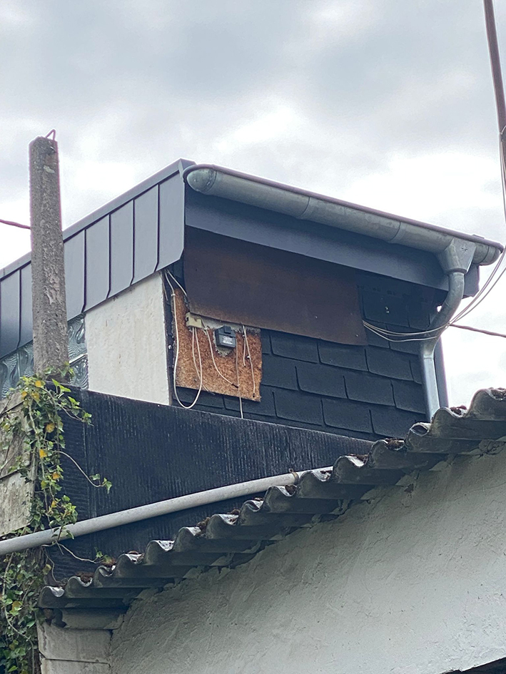 Dachgaube, die mit einer Spanplatte geflickt wurde