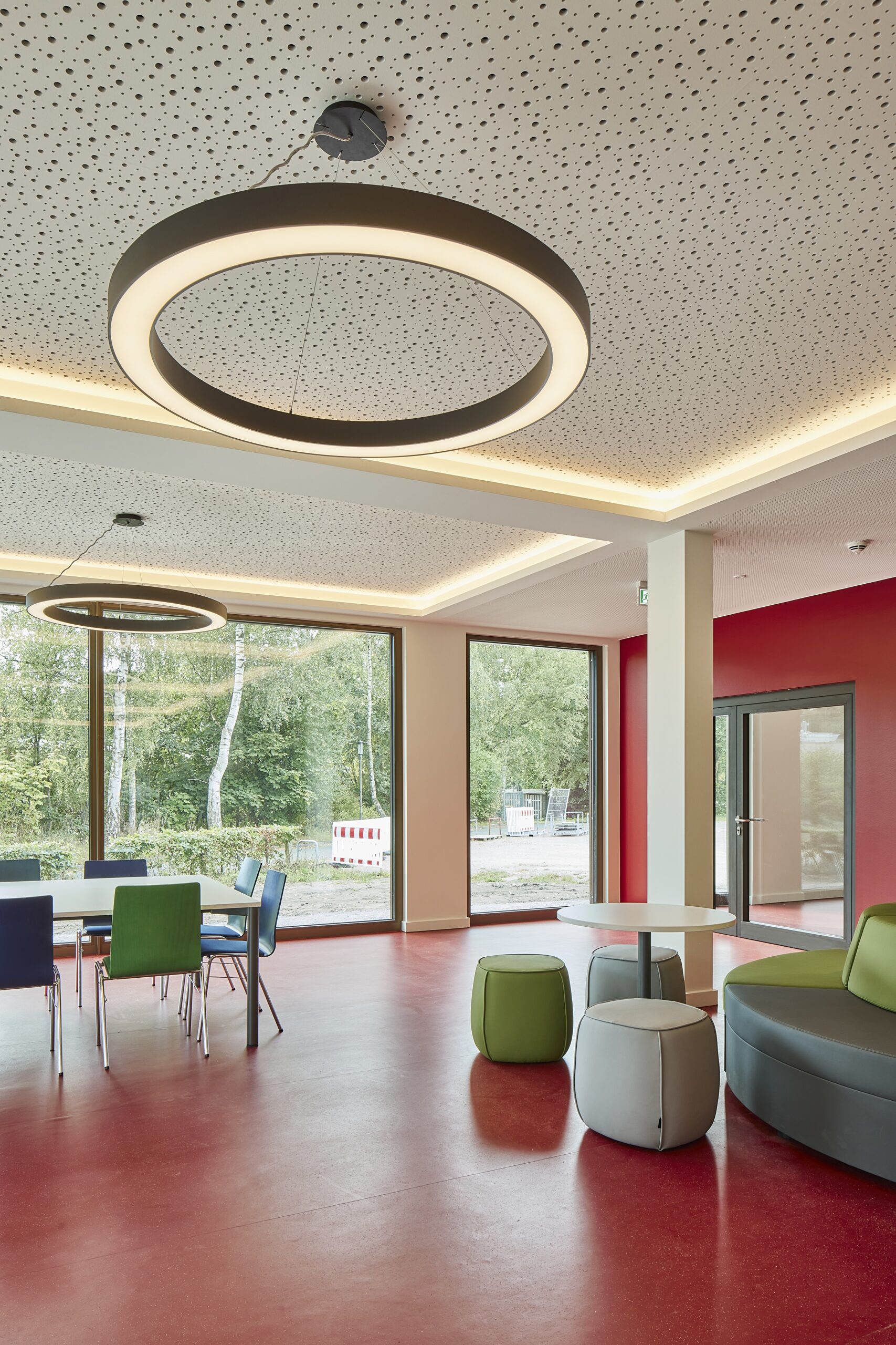 Schulflur mit bodentiefen Fenstern und Sitzgelegenheiten