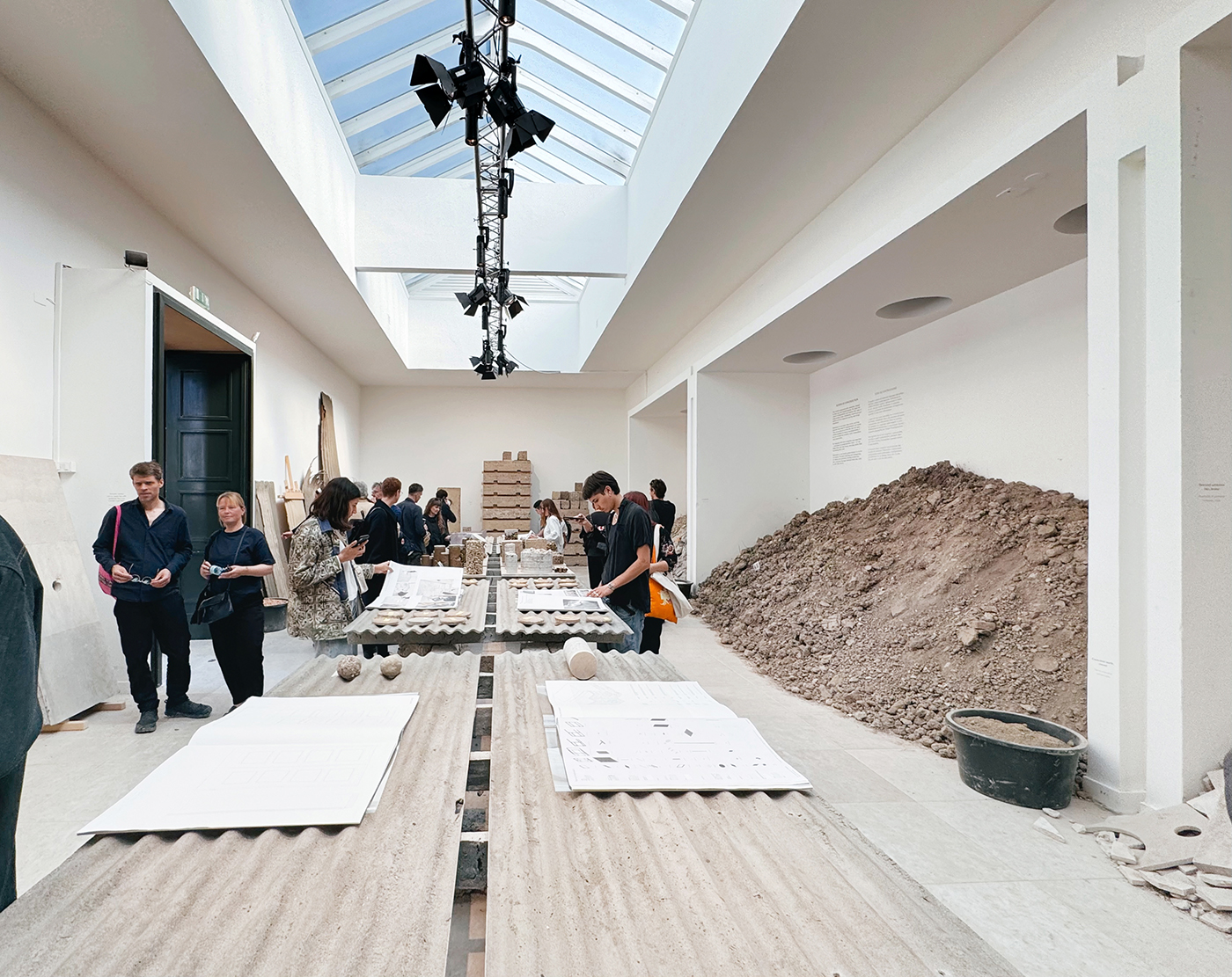 Ausstellungsraum mit weißen Wänden, Schutthaufen und Eternitplatten