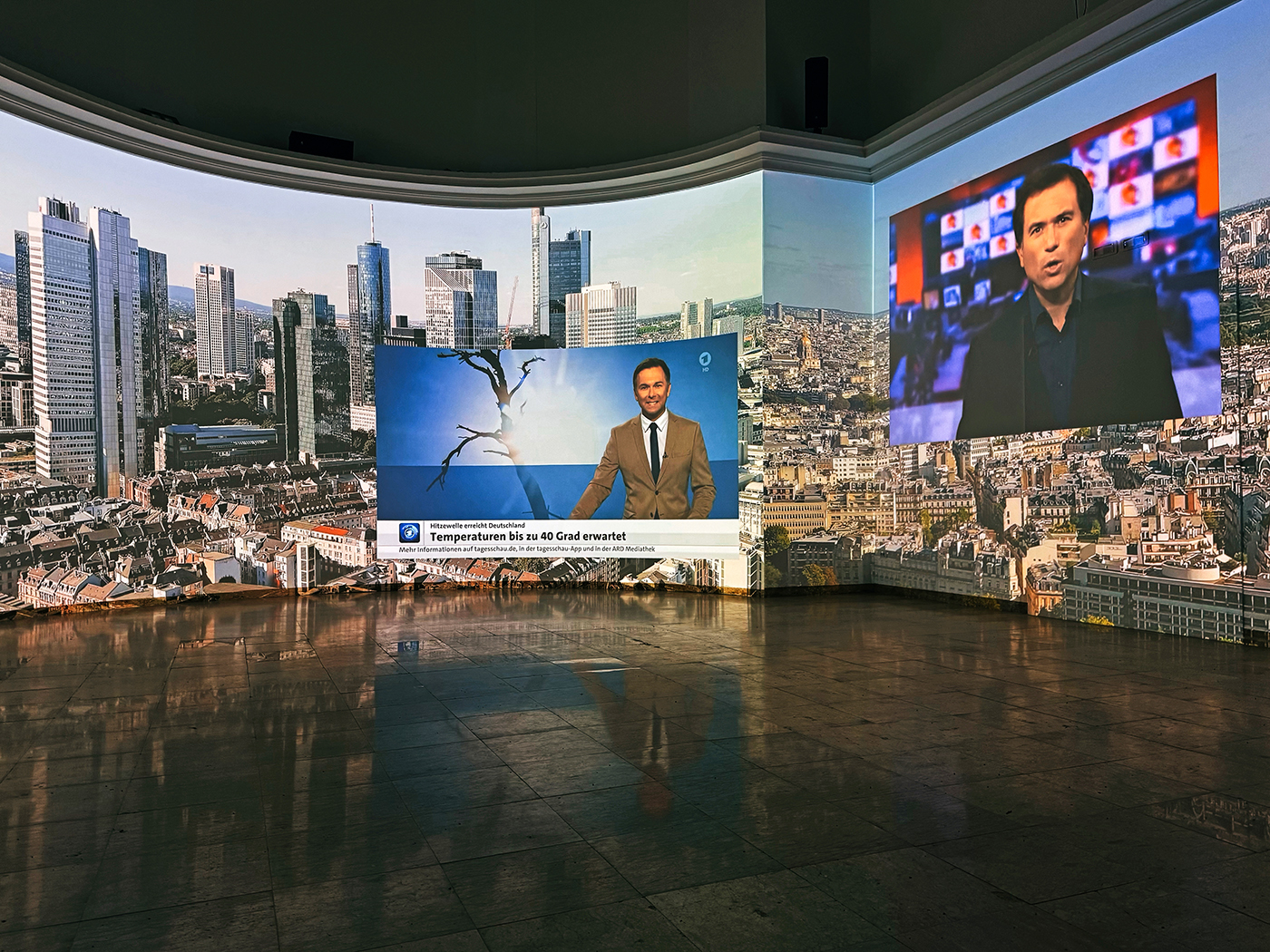 Videoinstallation mit Bildern von Städten und Nachrichtensprechern.