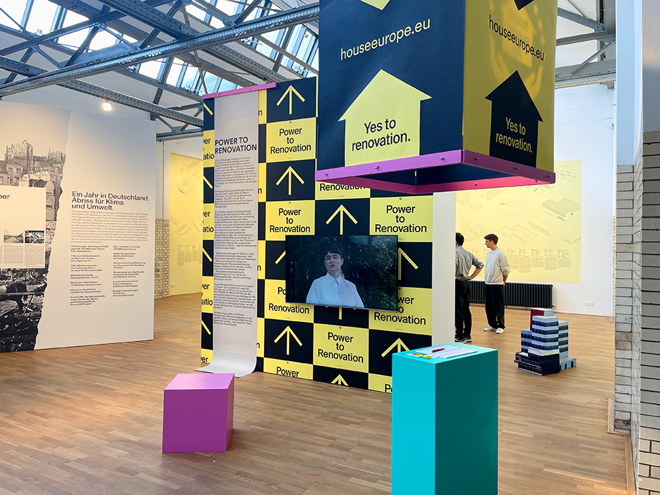 Der Ausstellungsraum mit einer Plakatwand und einem Videoscreen