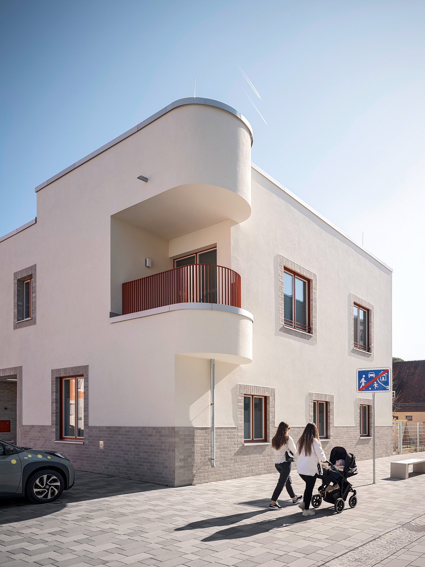 Weißes Eckhaus mit einem runden Balkon