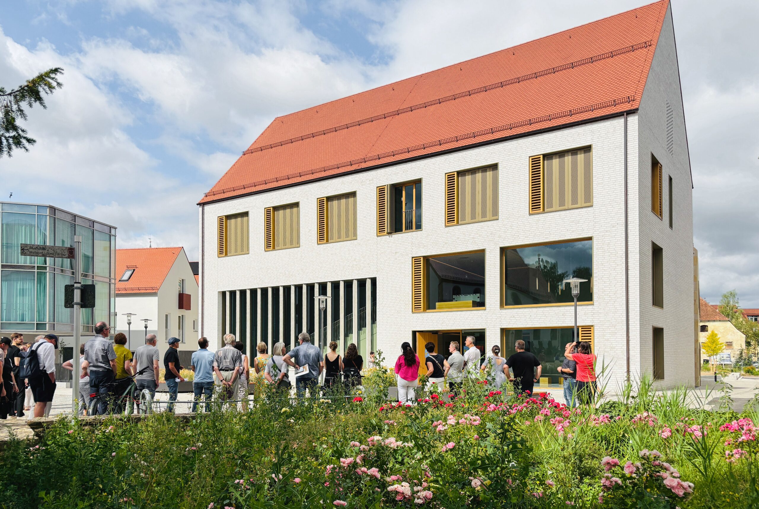 Gruppe vor Haus mit Giebel