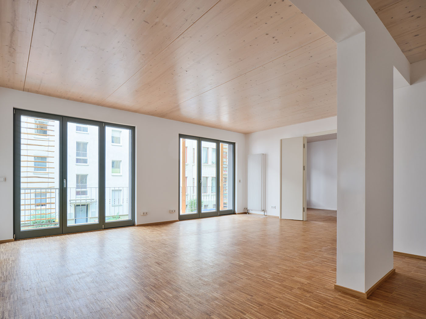 Heller Wohnraum mit bodentiefen Fenstern, Parkett und Holzdecke