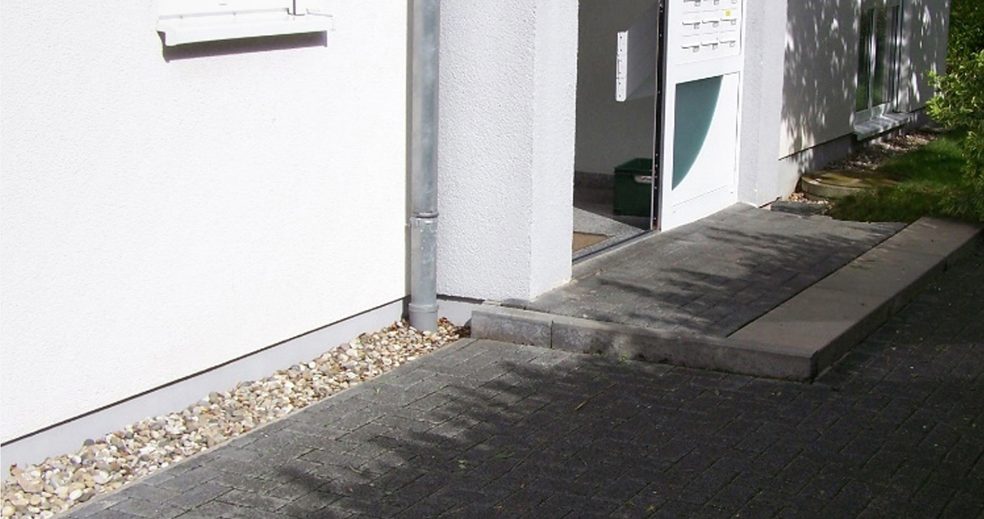 Hausfassade mit Kiesstreifen am Sockel