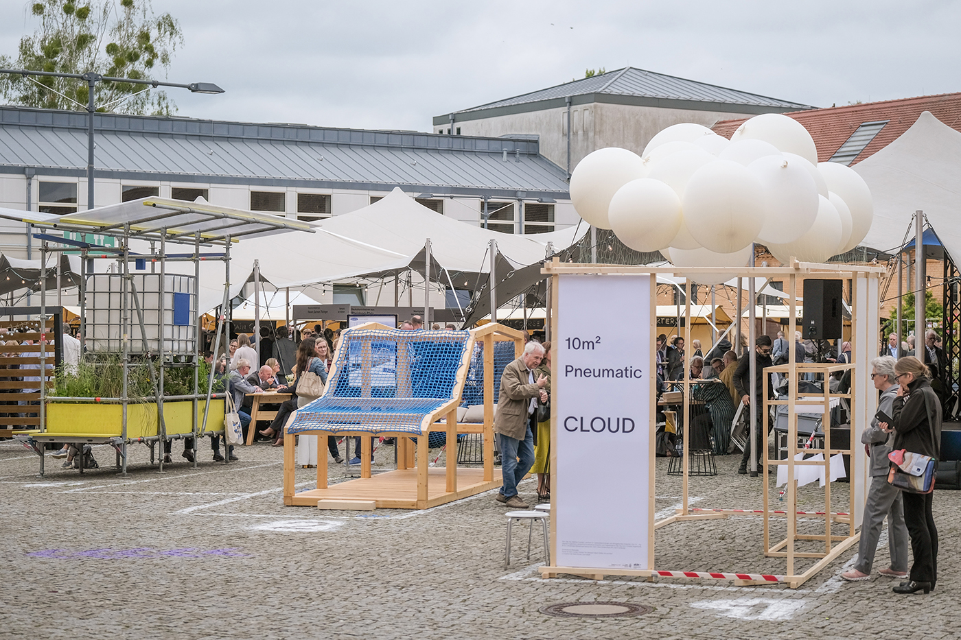 Besucher auf einem Ausstellungsgelände mit verschiedenen Objekten